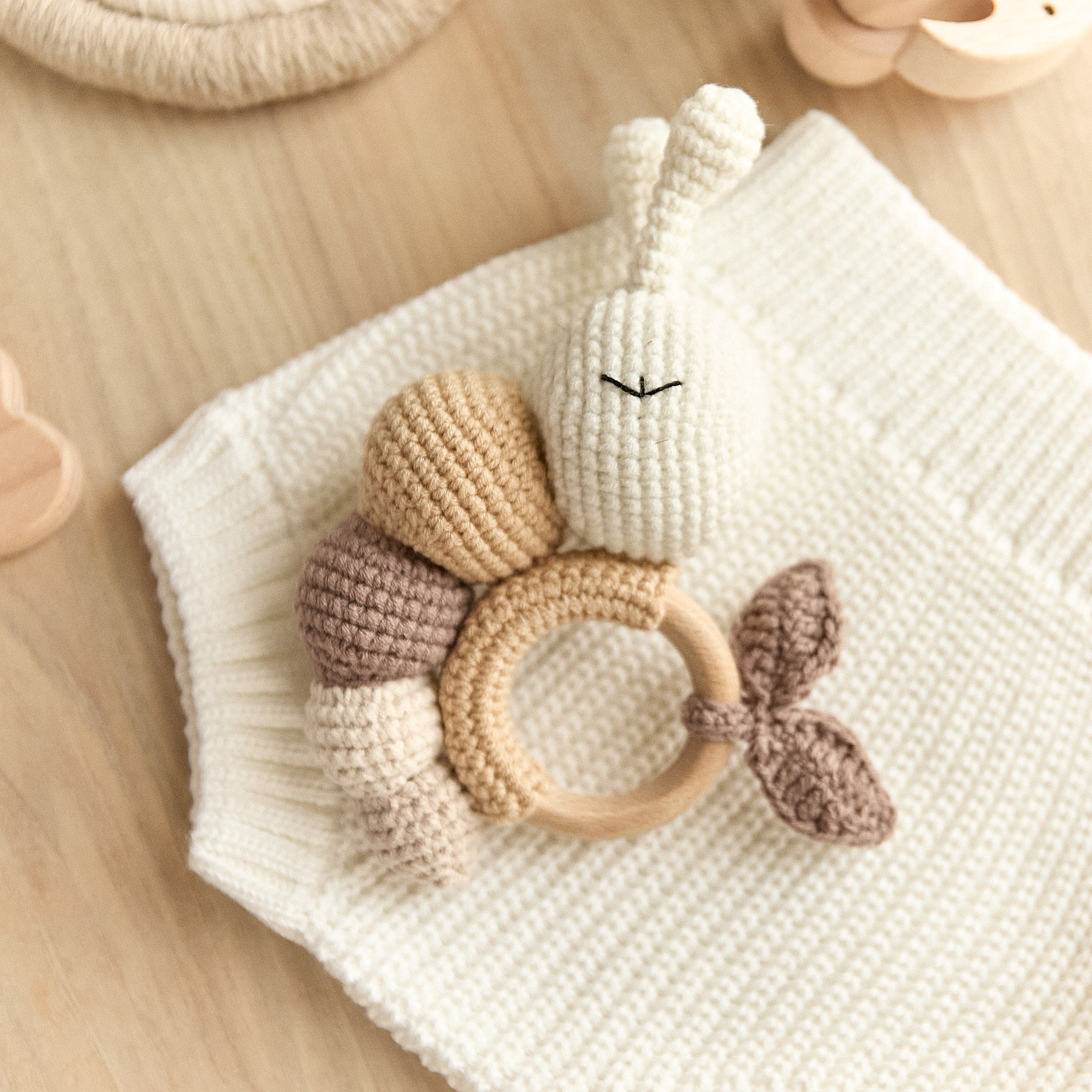 Handmade crochet caterpillar baby rattle on wooden teething ring