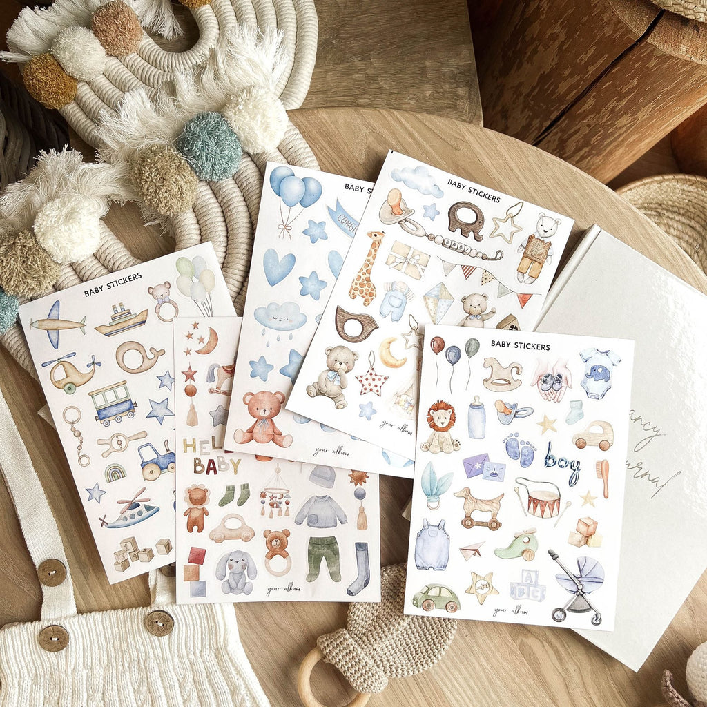Baby sticker sheets spread out showing pregnancy and newborn themed designs