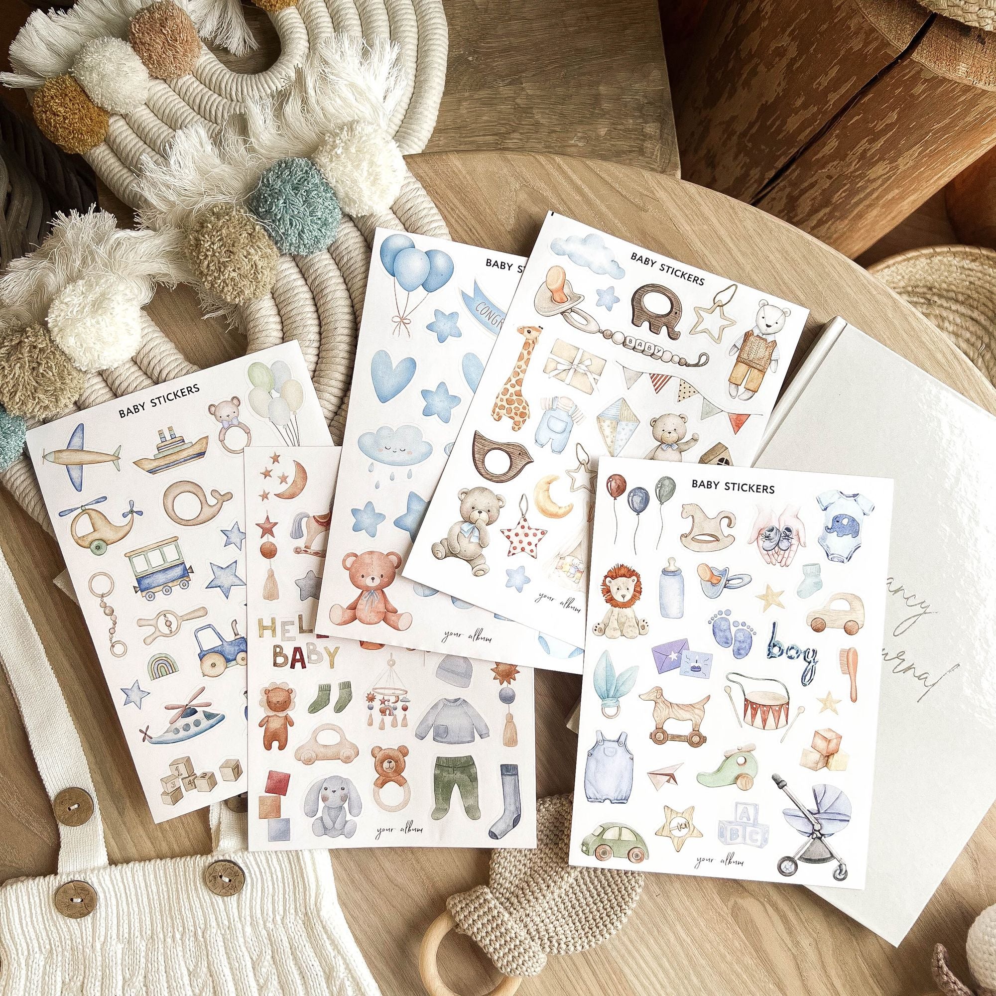 Baby sticker sheets spread out showing pregnancy and newborn themed designs