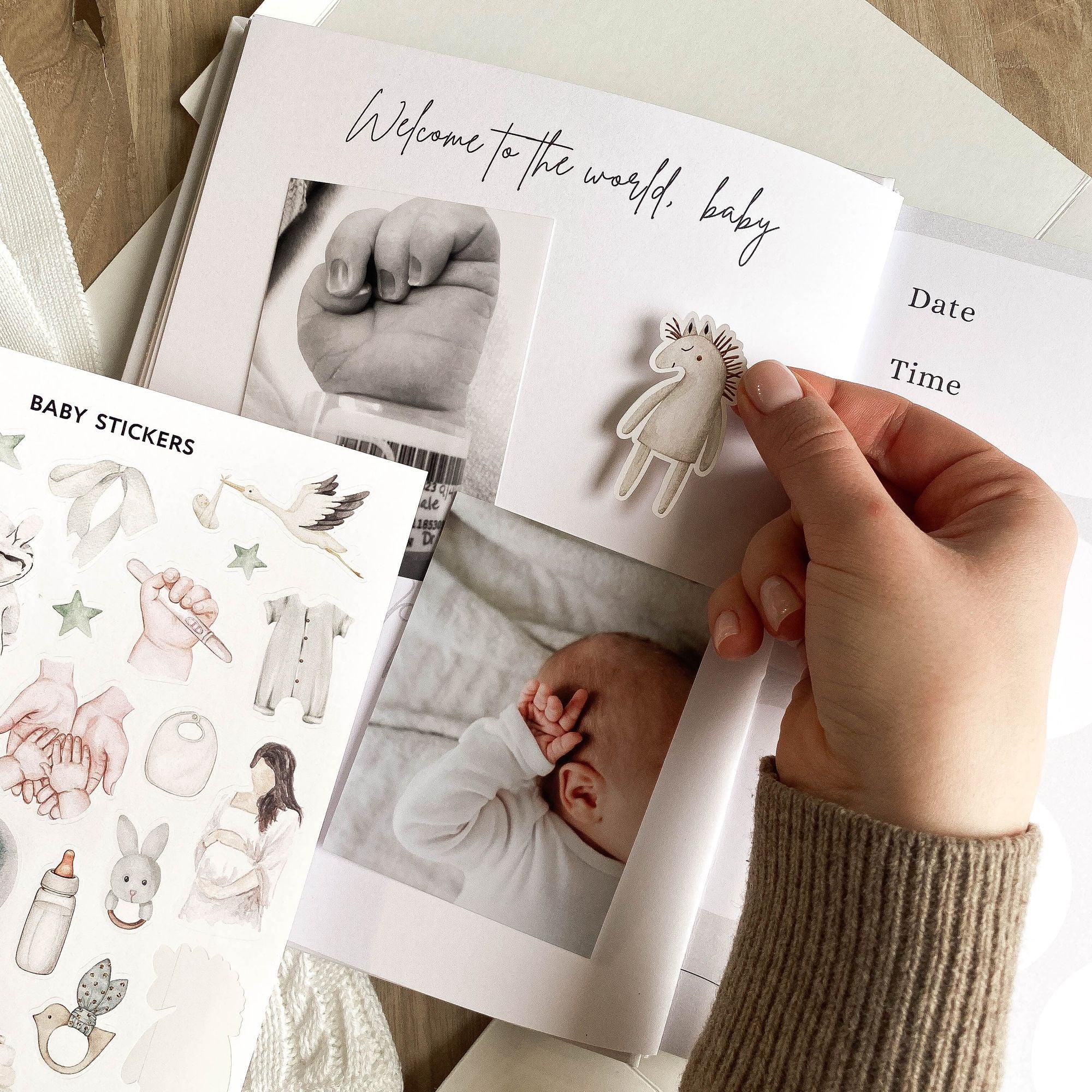 Close-up of baby album stickers with pastel watercolor illustrations and icons