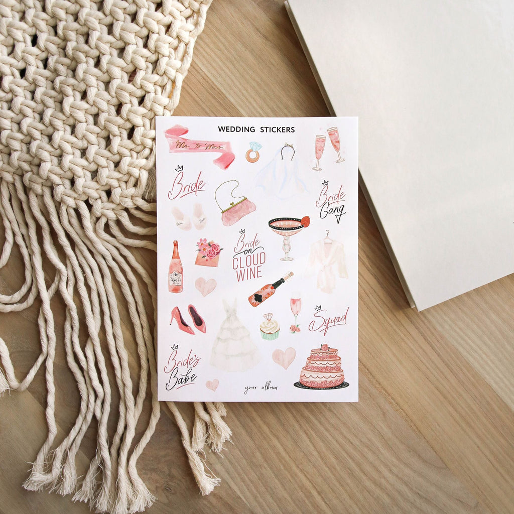 Close-up of wedding day sticker sheet with gold foil wedding icons and monograms