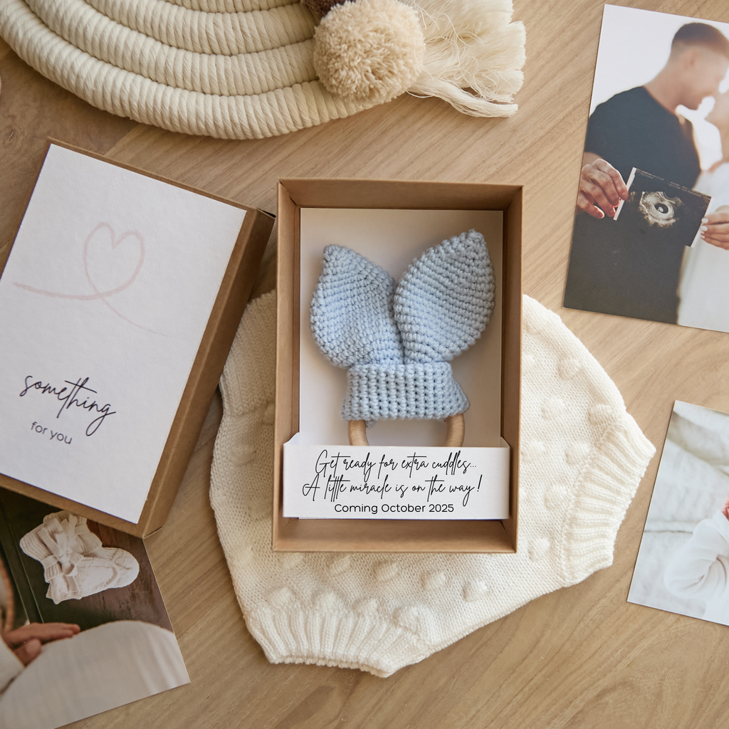 Pregnancy reveal gift box with blue crochet bunny ears for dad announcement